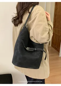 Detail der schwarzen Bucket Bag mit Kontrastnähten und seitlichem Schnallenriemen