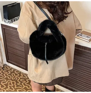 Détail du sac à main en peluche noire avec cordon à pompons et bandoulière en cuir