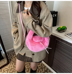 Détail d'un sac bandoulière en peluche rose avec fine lanière en cuir et texture douce