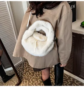 Détail d'un sac à bandoulière en fausse fourrure blanche porté par un mannequin féminin