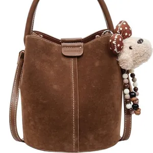 Brown suede bucket bag with leather carry handle and cute plush bear charm decoration