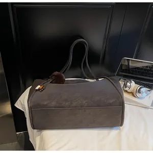 Détail du grand sac cabas en daim gris avec longues anses et pompon décoratif
