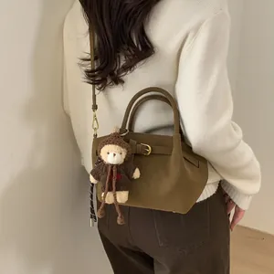 Deep brown suede bucket bag for women with a cute teddy bear charm and metal buckle