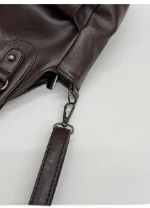 Detail of dark brown leather strap with gunmetal lobster clasp and reinforced stitching