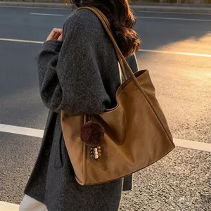 Sac cabas minimaliste en similicuir marron caramel avec pendentif pompon doux et déco