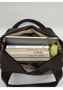 Top view of spacious brown tote bag interior with laptop, magazines, and umbrella