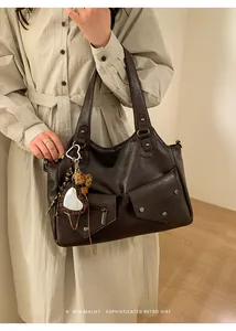 Detail of retro dark brown tote bag featuring twin front pockets and a heart-leopard charm