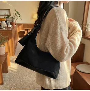 Detail view of the black crescent hobo bag with a detachable small coin purse accessory