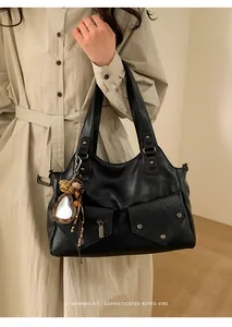 Minimalist black retro tote bag with leopard heart charm and rivet pocket detail