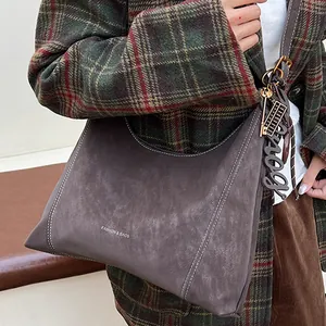 Large dark brown suede hobo bag with white stitching and fashion charms for women
