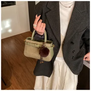 Detail of vintage bucket bag featuring green woven texture, leather handle and plush charm