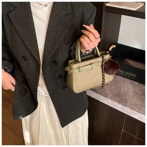 Detail of avocado green vintage bucket bag featuring fine leather texture and plush charm