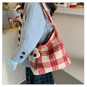 Detail view of the red plaid faux fur tote bag with a cute plush dog pendant charm