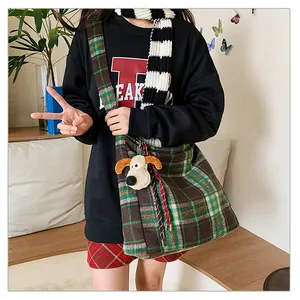 Detailed view of the checkered wool tote bag with a cute plush dog pendant charm