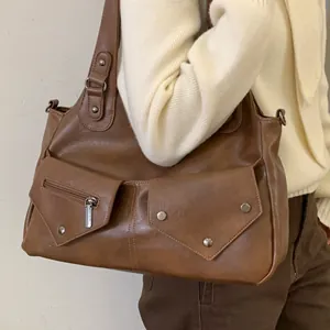 Vintage brown leather tote bag with functional pockets and silver rivets for commuting