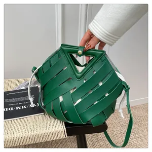Dettaglio borsa intrecciata verde con manico a triangolo e sacchetto interno con coulisse