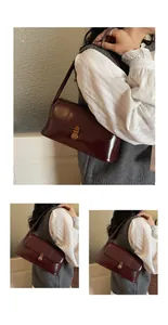 Detail of a vintage dark red baguette bag showing polished leather and bronze buckle
