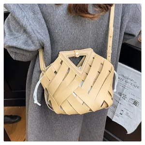Dettaglio della borsa a tracolla beige intrecciata con manico a triangolo e sacca interna