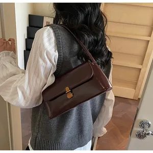 Detailed close-up of dark wine red leather underarm bag with vintage gold turn-lock closure