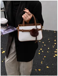 Close-up of white woven texture and brown leather trim on retro bucket bag for women