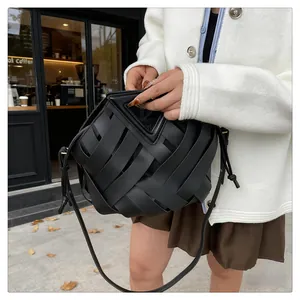 Dettaglio borsa a tracolla in pelle intrecciata nera con design unico del manico a triangolo