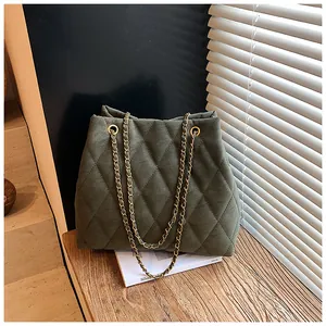 Detail van de donkergroene gewatteerde tote bag met gouden metalen kettingriem
