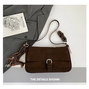 Deep brown crossbody bag featuring golden round buckle and cute dog-shaped charm