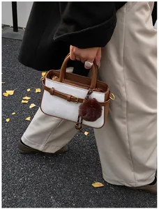 Detail of vintage bucket bag featuring textured fabric, leather trim and plush charm