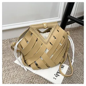 Dettaglio borsa a tracolla intrecciata kaki con manico triangolare e interno a coulisse