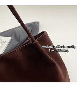 Dettaglio delle cuciture a contrasto e della trama in pelle scamosciata borsa marrone