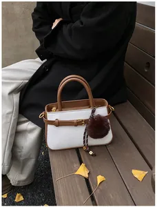 Detail of vintage bucket bag with woven fabric and leather trim on a wooden bench