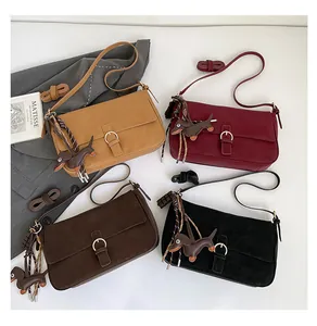 Close-up of vintage matte leather shoulder bags in four colors with dog charms