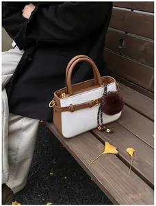 Detail of vintage bucket bag featuring woven texture and brown leather trim on a park bench