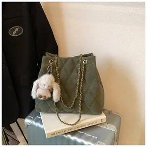 Detail van de donkergroene gewatteerde shopper met gouden ketting en wit pluchen konijn