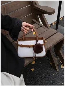 Detail of vintage bucket bag featuring white woven fabric and brown leather strap buckle