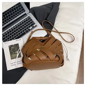 Dettaglio borsa intrecciata marrone con fodera interna bianca e tracolla sottile