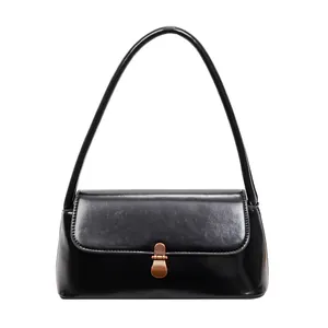 Classic black glossy leather shoulder bag with vintage bronze buckle and minimalist design
