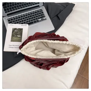 Dettaglio borsa a tracolla intrecciata bordeaux con fodera in tela color crema a coulisse