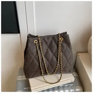 Detail van donkergrijze gewatteerde shopper met gouden ketting op getextureerde stof