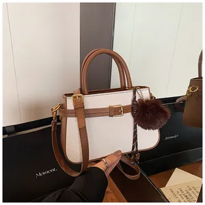 Detail showing white woven bucket bag texture with brown leather straps and gold metal hardware