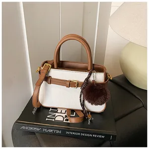 Detail of vintage bucket bag with woven fabric, leather straps and gold buckle accent
