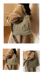 Detail of army green canvas tote bag featuring brown leather logo and wide shoulder strap
