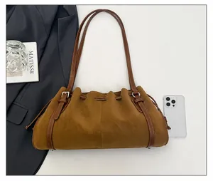 Vista superior de un bolso de hombro marrón vintage con cordón y comparación de tamaño