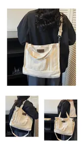 Detailed close-up of a white quilted canvas tote bag with brown leather label and silver hardware