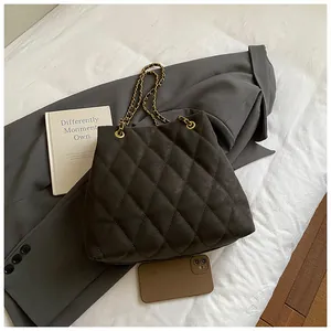 Macro-opname van donkergrijze gewatteerde shopper met elegante gouden kettingriem