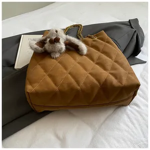Detail van de bruine gewatteerde shopper met gouden ketting en grijze konijnenhanger