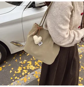 Chic suede tote bag with heart charm shown in a cozy autumn street photography setting
