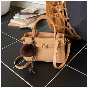 Detail of vintage bucket bag featuring woven texture with decorative fur ball and M-charm