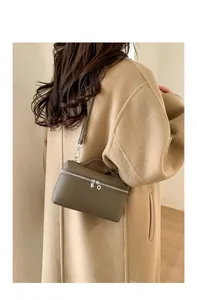 Detail of lychee textured leather box bag with dual silver zippers and slim strap