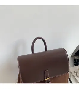 Detail of round top handle on brown faux leather backpack for comfortable grip